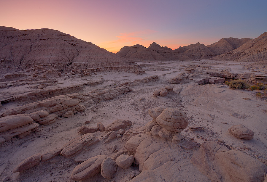 The warm glow of the sunrise radiants from the east bathing the otherworldly Toadstool Geologic Park in etheral warm hues. - Toadstool Geologic Park Photography