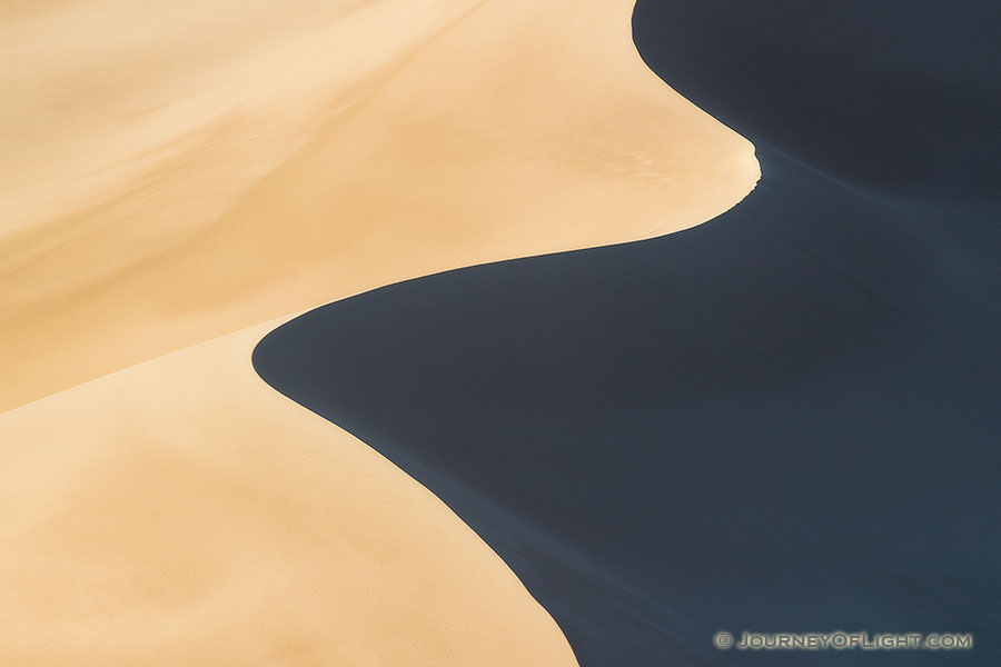 Morning sun streams across Great Sand Dune National Park and Preserve creating contrasts among the dunes. - Colorado Photography