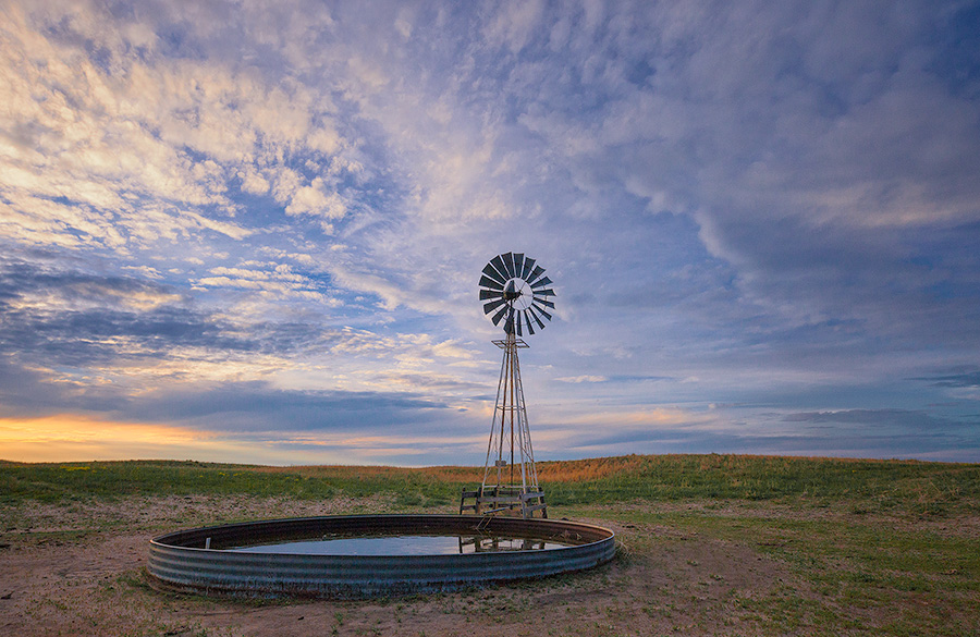 Dusk falls as clouds hover over a remote windmill in McKelvie National Forest in western Nebraska. - Sandhills Photography