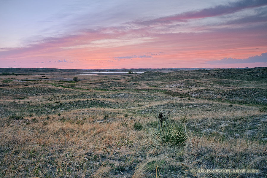 As the sun sets, the clouds ablaze with red hues over the undulating hills of central Nebraska. - Valentine Photography