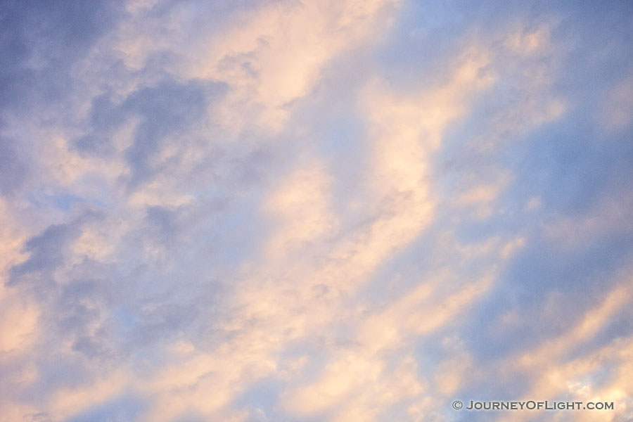 Light from the setting sun illuminates clouds in an abstract pattern on a chilly February evening. - Nebraska Photography