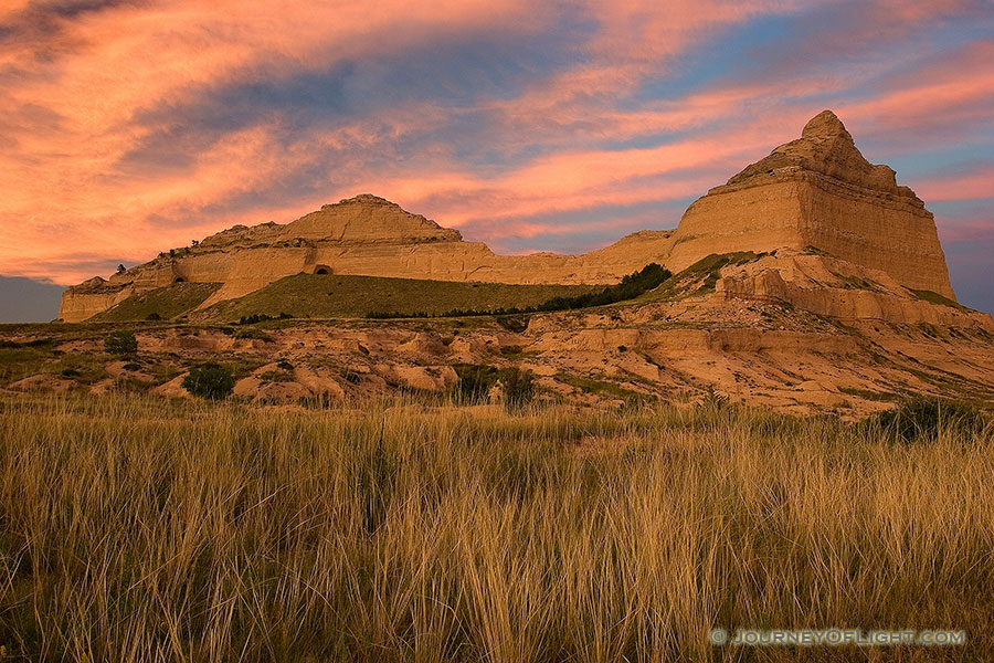 Scotts Bluff National Monument in western Nebraska.  Towering eight hundred feet above the North Platte River, Scotts Bluff has been a natural landmark for many peoples, and it served as the path marker for those on the Oregon, California, Mormon, and Pony Express Trails.  Scotts Bluff National Monument preserves 3,000 acres of unusual land formations which rise over the otherwise flat prairieland below. - Nebraska Photography