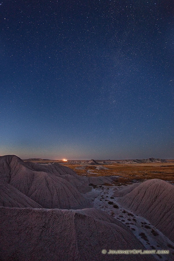 Stars fill the night sky while a train waits on the horizon at Toadstool Geologic Park near Chadron in western Nebraska. - Toadstool Photography