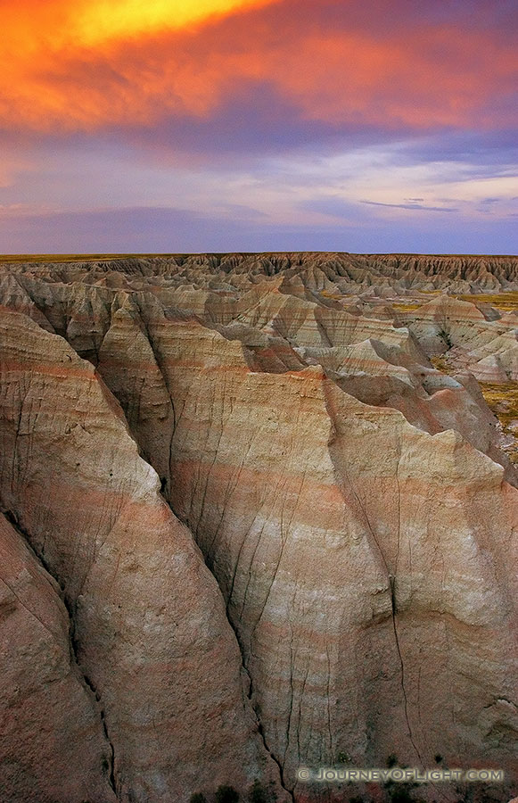 Fiery reds and oranges dominate the sunset over the Badlands National Park in South Dakota. - Badlands NP Photography