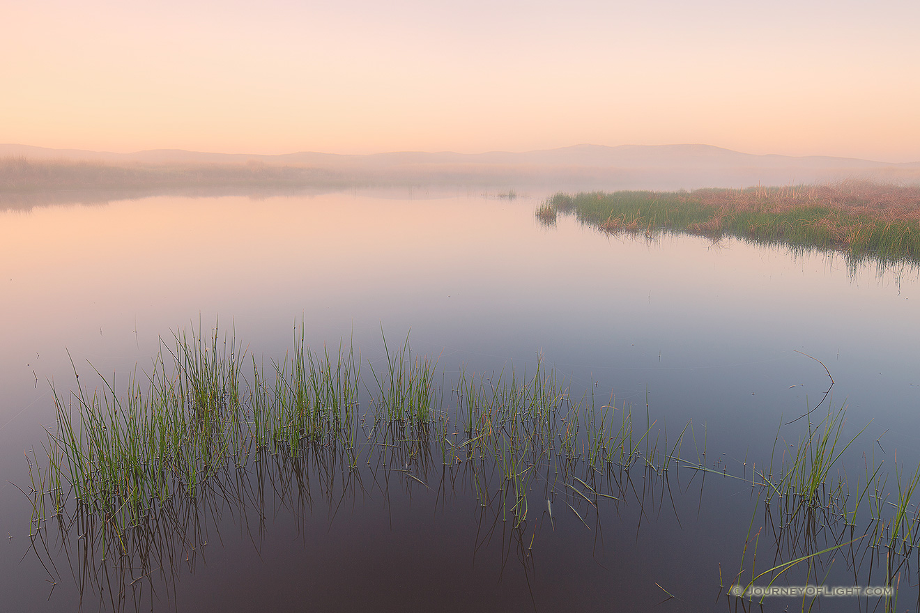 When I visited Crescent Lake National Wildlife Refuge this past May one of the things that struck me about the refuge was the quiet and remoteness.  Early one morning I hiked out to a little marshy area that was completely encased in fog.  I setup on the edge of one of the marshes and watched as the fog rolled through and eventually burned off.  The only sounds were the quacks of some ducks on a nearby lake and the rustle of prairie grass in a light breeze. - Nebraska Picture