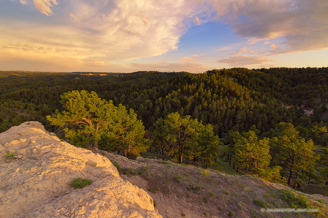 In the extreme Northwestern edge of Nebraska, north of Harrison is a little WMA called Gilbert-Baker WMA.  On this cool spring evening, I hiked for a couple of miles over a few hills and then sat on this rock content to eat my dinner and watch a storm brew in the distance and then dissipate, leaving interesting clouds to reflect the light of the setting sun. - Nebraska Picture