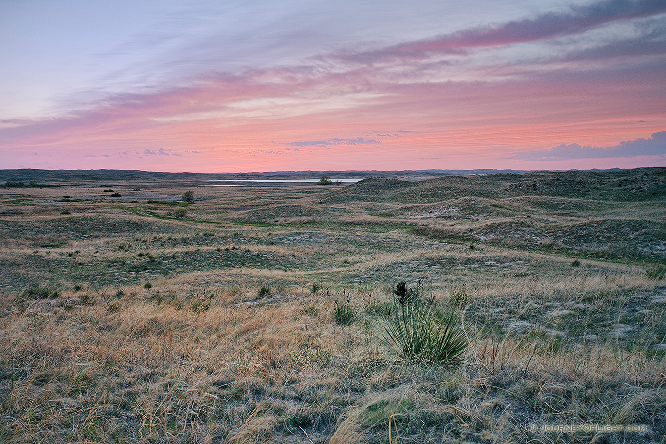 As the sun sets, the clouds ablaze with red hues over the undulating hills of central Nebraska. - Valentine Picture