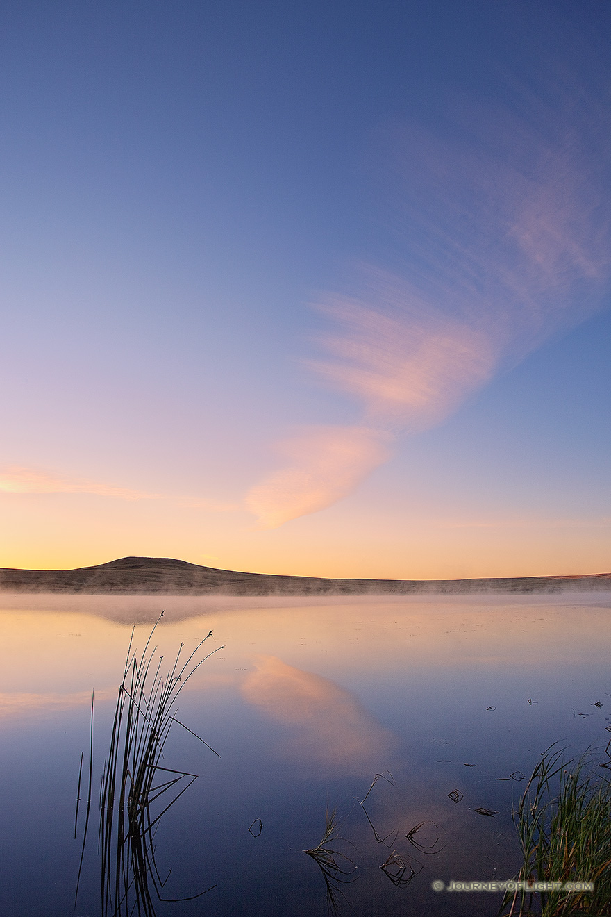 On a cool autumn morning, mist rises from Meng Reservoir on the Oglala Grassland while a single clouds hovers over the lake. - Nebraska Picture