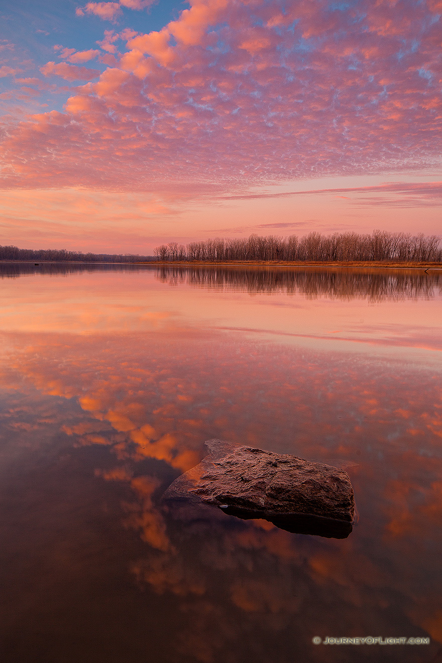 With nary a breeze and no other soul in sight, I enjoyed the vibrant colors brought forth from this sunrise in a quiet peacefulness and solitude. - Nebraska Picture