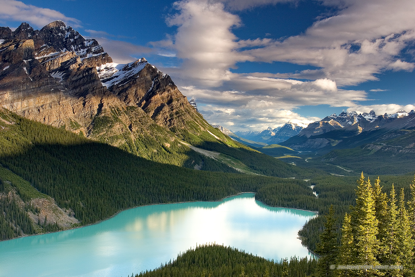 Peyto Lake in Banff National Park is known for its turquoise blue water caused by runoff from the nearby Glacier.  Most photographers will tell you to photograph this scene in the afternoon in order to maximize the reflection of the mountains on the lake.  I, however, wanted to see how it would look in the early morning.  After photographing the sunrise on Bow Lake I traveled the short distance to Peyto Lake to capture this image. - Banff Picture